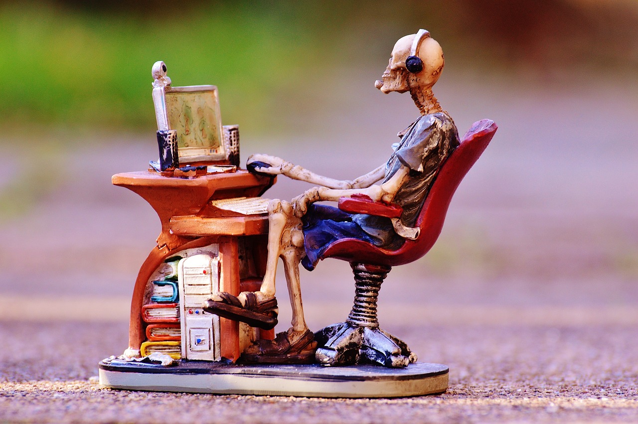 skeleton sitting at computer desk